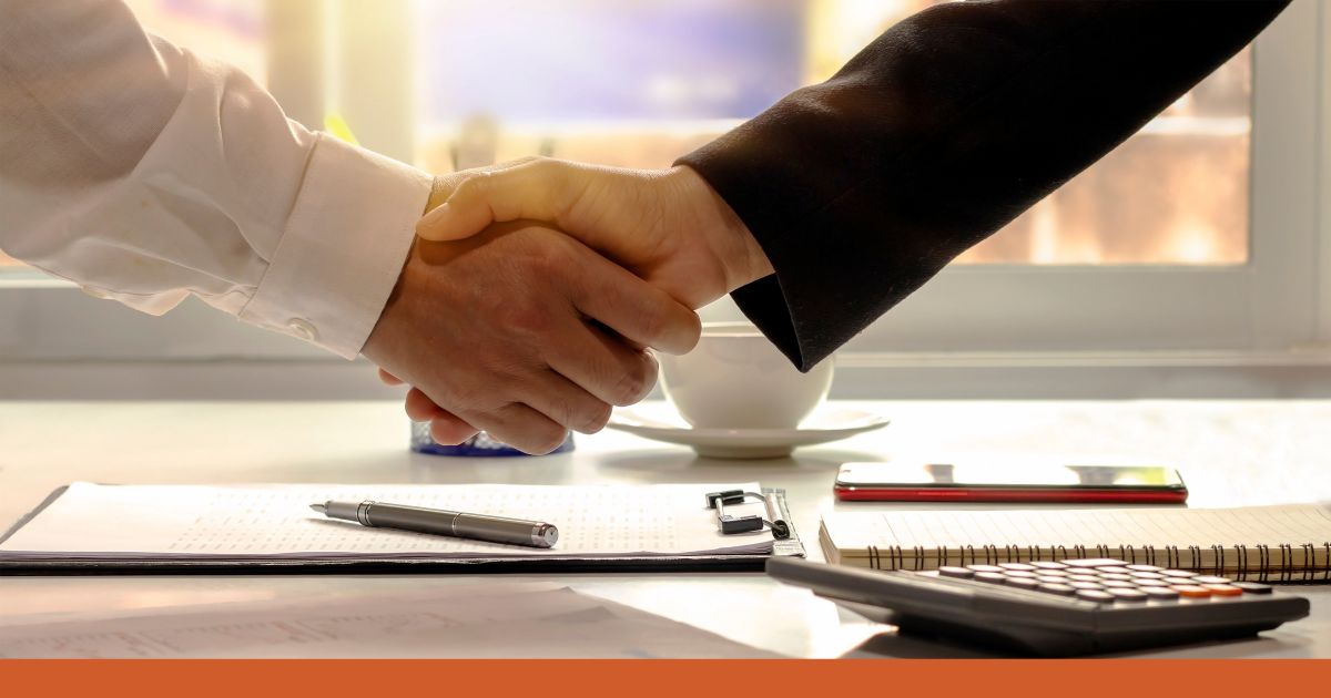 Das Bild zeigt zwei Geschäftsleute, die sich die Hand geben, was den Abschluss einer Vereinbarung symbolisier. Es geht um Verhandlungstechniken im Vertrieb. Überschrift: Wie Sie Ihre Verhandlungstechniken optimieren und erfolgreich abschließen.